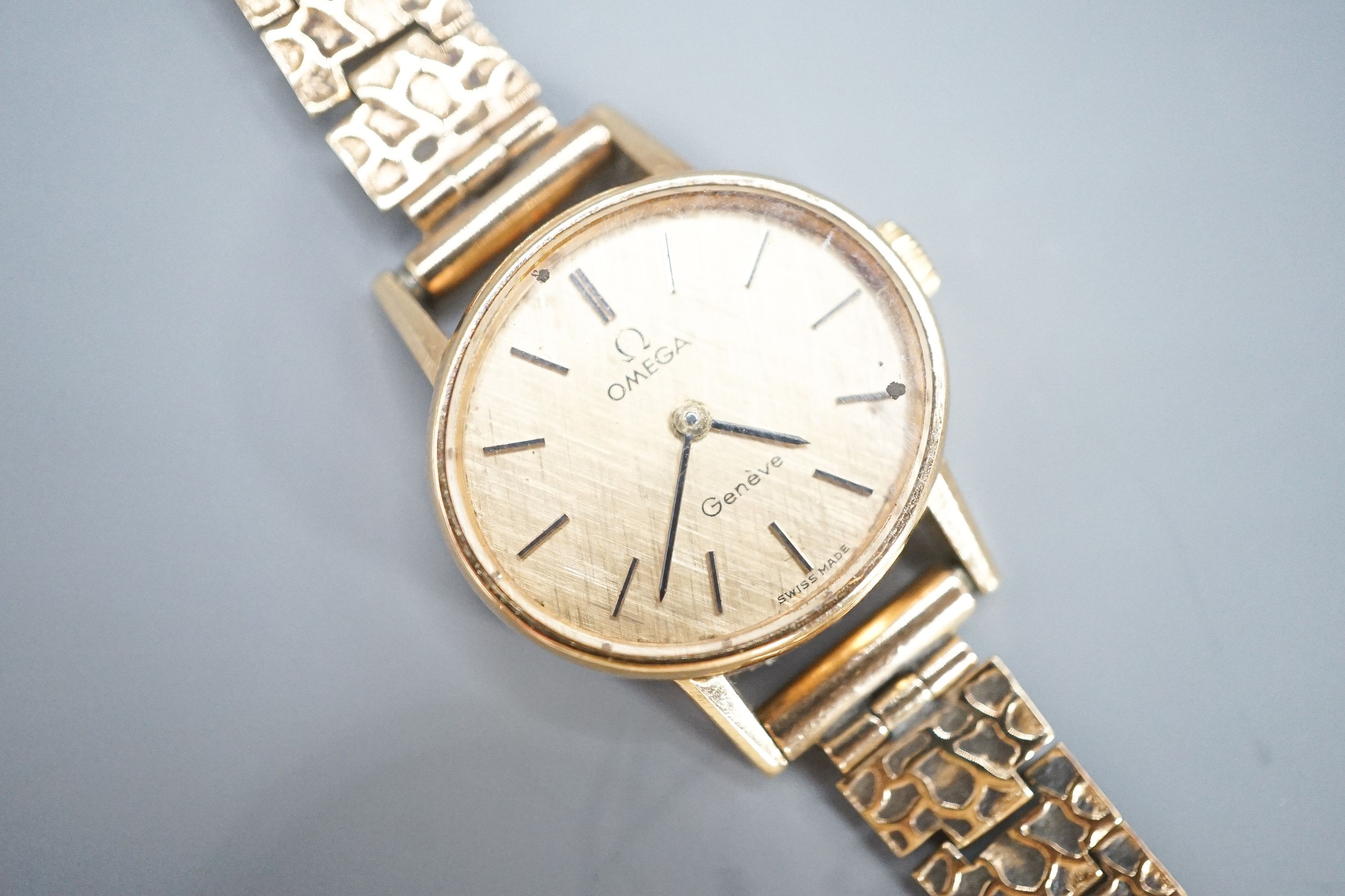 A lady's 1970's 9ct gold Omega manual wind wrist watch, on a 9ct gold bracelet, overall 18.5cm